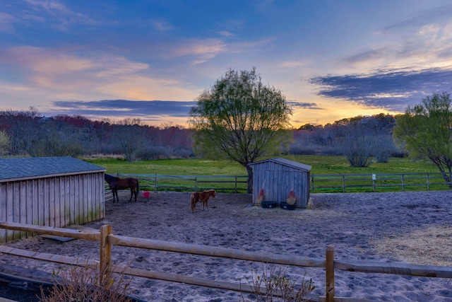 view of yard with a rural view, an outbuilding, and an enclosed horse arena