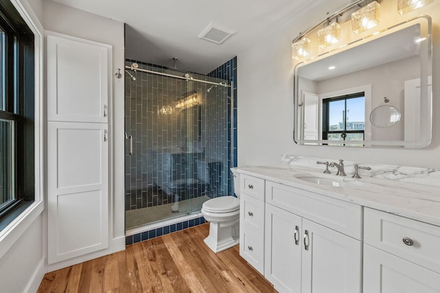 full bath with wood finished floors, a shower stall, toilet, and vanity