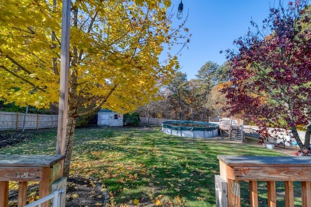 view of yard featuring a storage shed and a covered pool