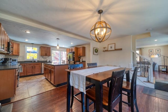 dining space with sink, a notable chandelier, and light hardwood / wood-style flooring