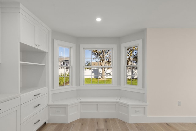 interior space featuring light wood-type flooring, a decorative wall, and recessed lighting