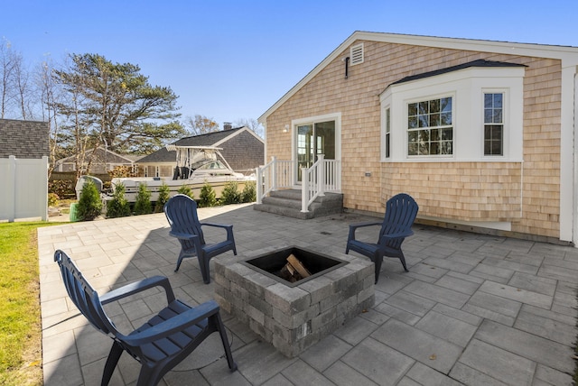 view of patio / terrace with fence and a fire pit