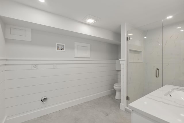 full bathroom featuring toilet, a marble finish shower, and vanity