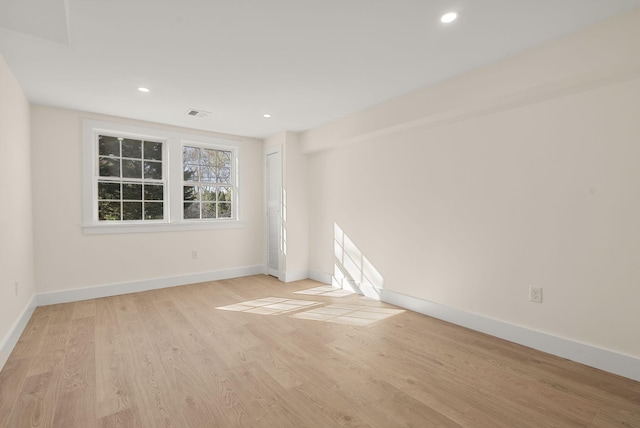 unfurnished room with recessed lighting, wood finished floors, visible vents, and baseboards