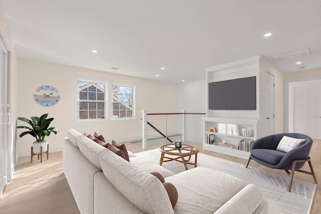 living area featuring baseboards, visible vents, wood finished floors, and recessed lighting