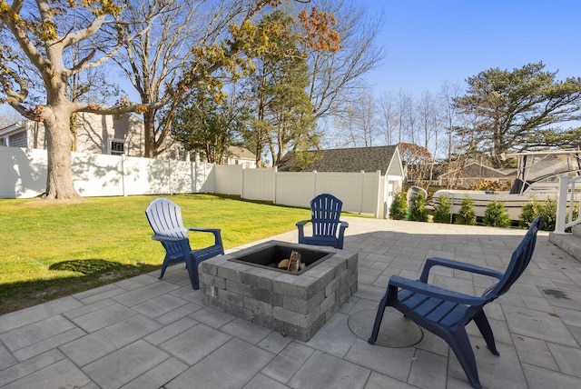 view of patio / terrace featuring a fire pit, an outdoor structure, and a fenced backyard