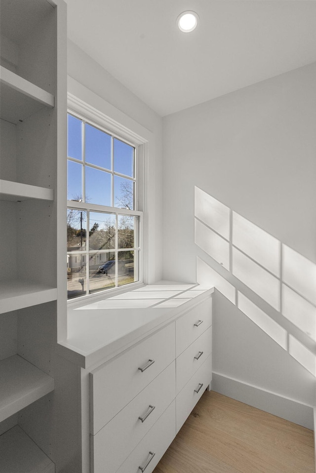 walk in closet with light wood-style flooring