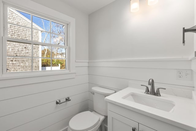 bathroom featuring a wainscoted wall, vanity, and toilet