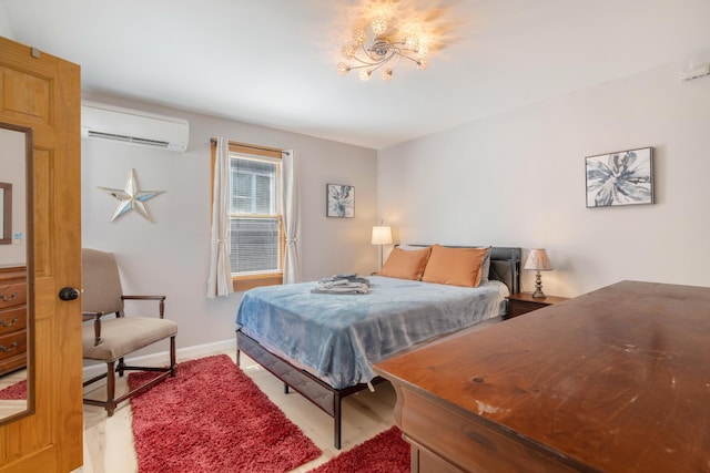 bedroom featuring a wall mounted AC and light hardwood / wood-style flooring