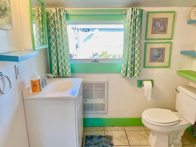 bathroom with vanity, toilet, heating unit, and tile patterned flooring