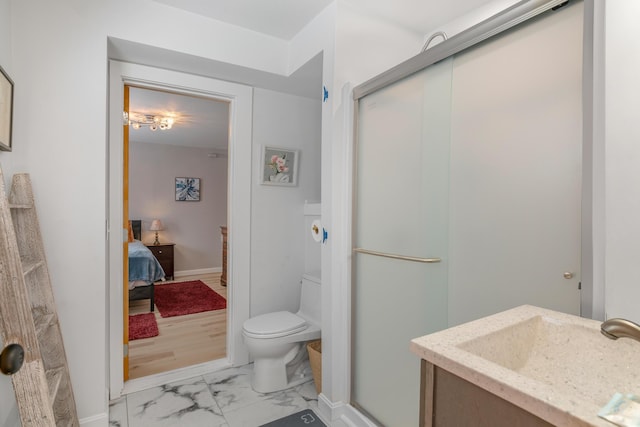 bathroom featuring vanity, toilet, and a shower with shower door