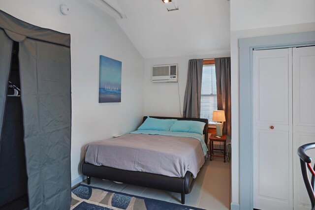 bedroom featuring a closet, vaulted ceiling, and an AC wall unit