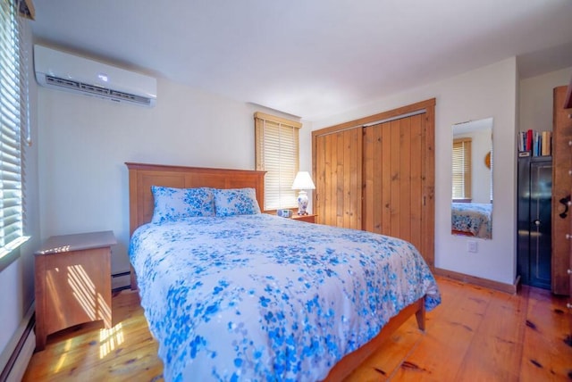 12 Tree Top Ln, East Falmouth, MA 02536 - bedroom with an AC wall unit, light wood-style flooring, a baseboard radiator, a closet, and a baseboard heating unit