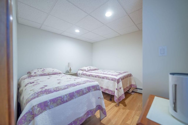 12 Tree Top Ln, East Falmouth, MA 02536 - bedroom featuring a baseboard heating unit, wood finished floors, recessed lighting, and a paneled ceiling