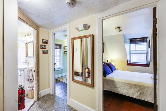 carpeted bedroom featuring a textured ceiling and multiple windows