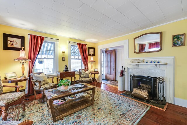 living room featuring crown molding, a fireplace, and dark hardwood / wood-style flooring