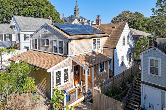 rear view of property featuring solar panels