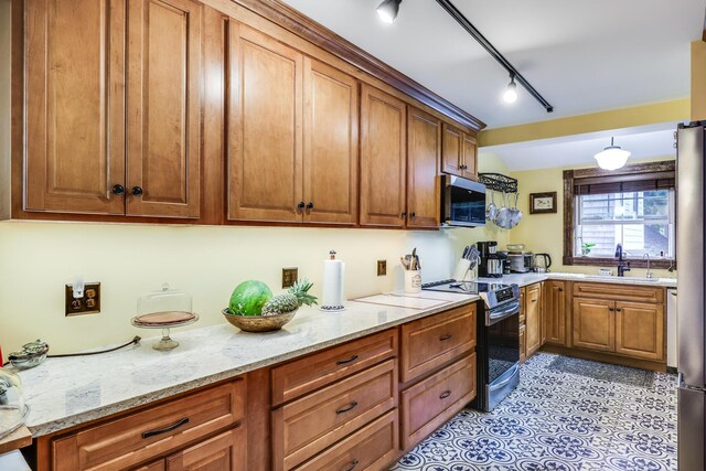 kitchen featuring sink, light stone countertops, and stainless steel appliances