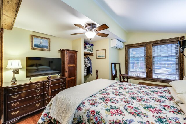 bedroom featuring ceiling fan, hardwood / wood-style floors, and a wall mounted AC