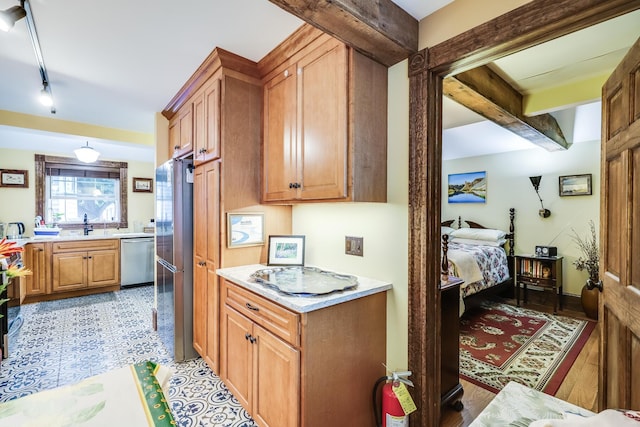 kitchen with beam ceiling, track lighting, and appliances with stainless steel finishes