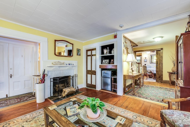 living room with built in shelves, crown molding, and dark hardwood / wood-style floors