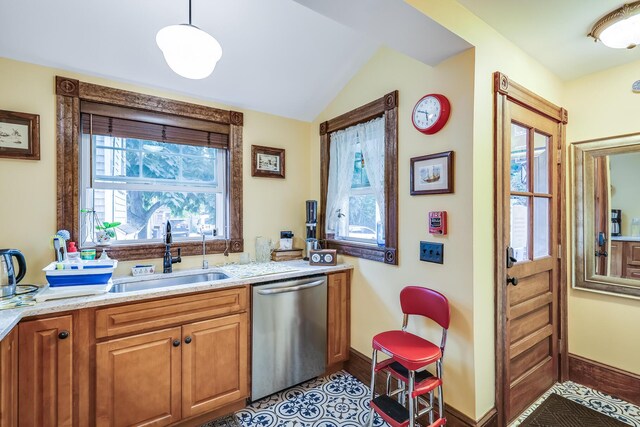 kitchen with sink, decorative light fixtures, a wealth of natural light, and stainless steel dishwasher