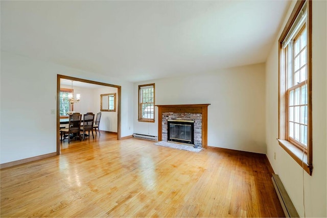 31 Woodridge Rd, East Sandwich, MA 02537 - living area featuring a baseboard heating unit, a chandelier, light wood-style floors, a baseboard radiator, and a fireplace