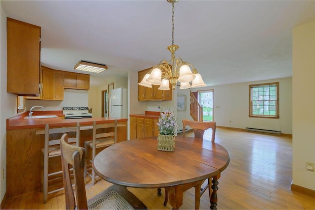 31 Woodridge Rd, East Sandwich, MA 02537 - dining area with baseboard heating, light wood-style flooring, a chandelier, baseboards, and a baseboard radiator