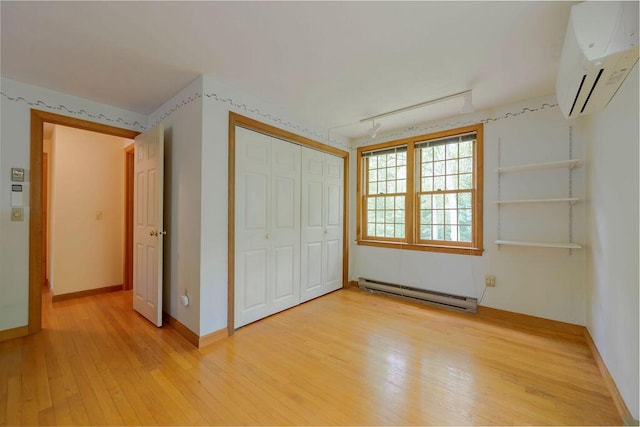 31 Woodridge Rd, East Sandwich, MA 02537 - unfurnished bedroom featuring a baseboard heating unit, a wall mounted air conditioner, light wood finished floors, a closet, and baseboards
