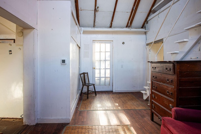 interior space with lofted ceiling with beams and dark hardwood / wood-style floors