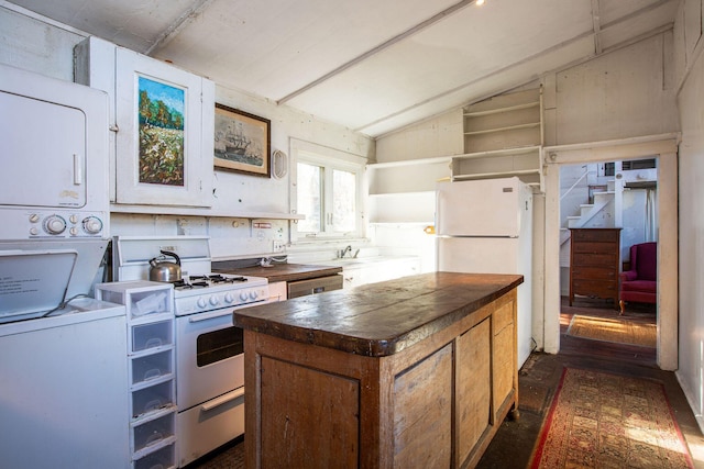 kitchen featuring stacked washing maching and dryer, white appliances, tile countertops, a kitchen island, and lofted ceiling