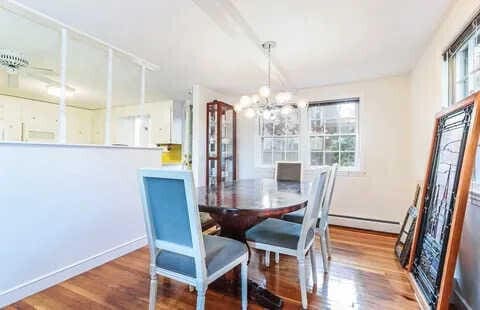 dining room with a baseboard heating unit, hardwood / wood-style flooring, and a notable chandelier