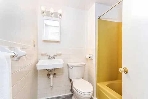 full bathroom featuring sink, tile walls, bathtub / shower combination, and toilet