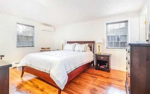 bedroom featuring light hardwood / wood-style floors and a wall unit AC