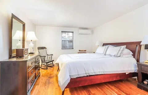 bedroom featuring a wall mounted AC and light hardwood / wood-style floors