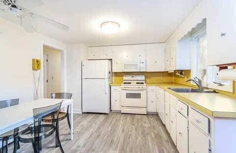 kitchen featuring white appliances, light hardwood / wood-style floors, sink, and white cabinets