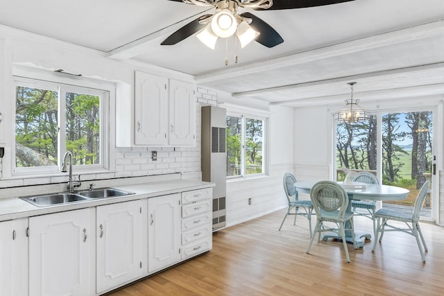 190 Meadow Ave W, Wellfleet, MA 02667 - kitchen featuring a heating unit, white cabinets, light countertops, beamed ceiling, and decorative light fixtures