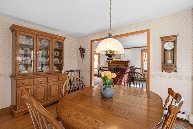 dining space with wood-type flooring and ornamental molding