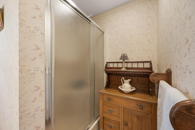 bathroom featuring crown molding, a shower with door, and vanity