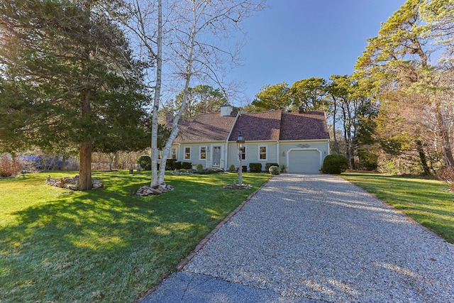 view of front of home with a garage, driveway, a chimney, and a front yard