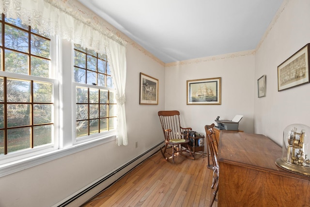 office area with a wealth of natural light, baseboard heating, and wood-type flooring