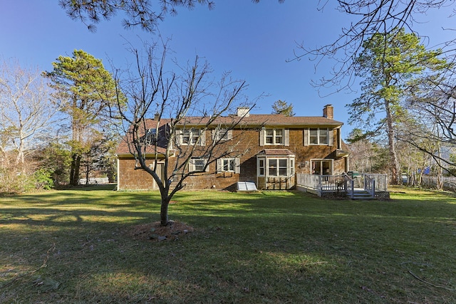 rear view of house featuring a lawn and a wooden deck