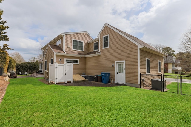 31 Seatucket Rd, East Falmouth, MA 02536 - rear view of property with fence, central AC unit, and a lawn