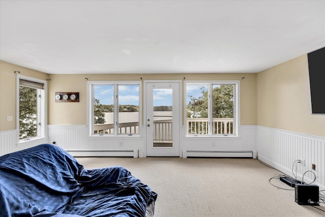 sitting room with a wainscoted wall, a baseboard radiator, and carpet