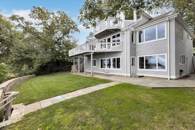 rear view of property with a patio area, a lawn, a deck, and stairs