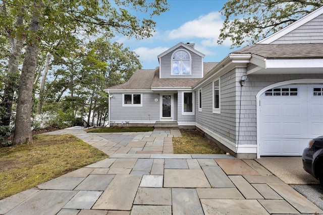 view of front of house with roof with shingles and an attached garage