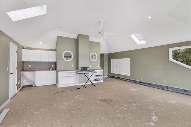 kitchen featuring a skylight, baseboards, a ceiling fan, baseboard heating, and white cabinetry