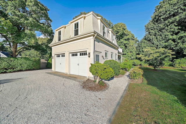 view of property exterior with a garage and a lawn