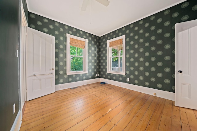 spare room featuring light hardwood / wood-style floors, ceiling fan, and ornamental molding