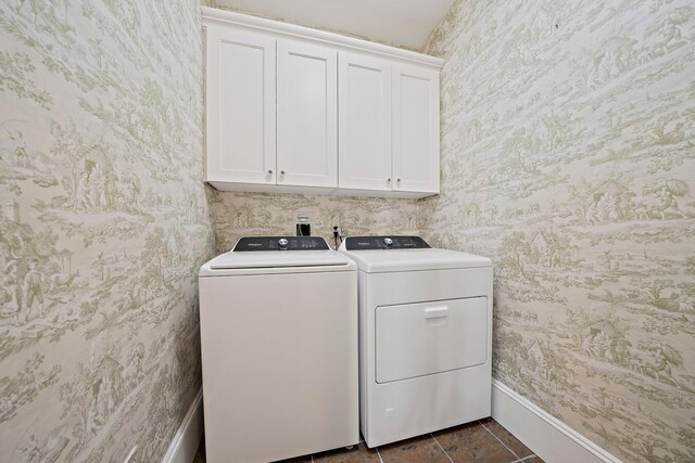 laundry room with dark tile patterned flooring, cabinets, and independent washer and dryer